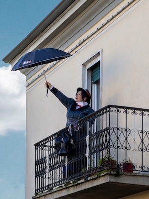 Mary Poppins su un balcone che fa per volare con l'ombrello AIUM